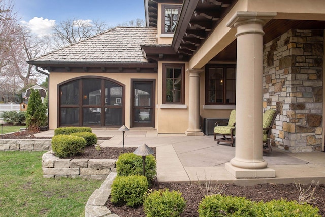entrance to property featuring a patio and stucco siding