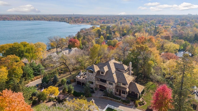 birds eye view of property with a water view and a wooded view