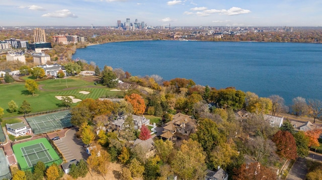 drone / aerial view featuring a city view, view of golf course, and a water view