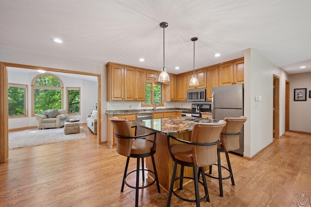 220 Willow Ln, Foley, MN 56329 - kitchen featuring stainless steel appliances, light wood-type flooring, a breakfast bar, a kitchen island, and recessed lighting