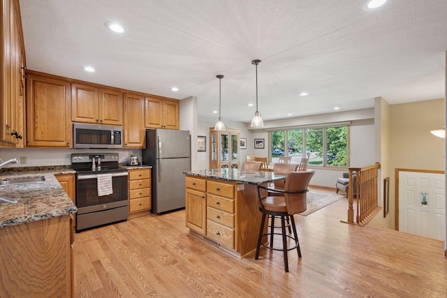 220 Willow Ln, Foley, MN 56329 - kitchen with appliances with stainless steel finishes, a kitchen breakfast bar, stone countertops, light wood-type flooring, and recessed lighting