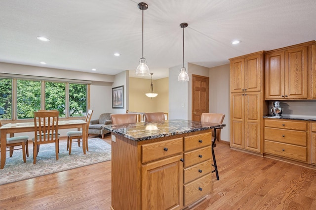 220 Willow Ln, Foley, MN 56329 - kitchen with light wood-style floors, dark stone counters, a center island, decorative light fixtures, and recessed lighting