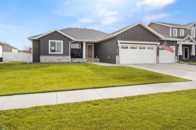 3682 Merrifield Dr S, Fargo, ND 58104 - view of front of home featuring board and batten siding, stone siding, a garage, driveway, and central air condition unit