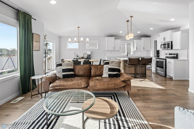 3682 Merrifield Dr S, Fargo, ND 58104 - living room featuring dark wood-style floors, baseboards, recessed lighting, and a chandelier