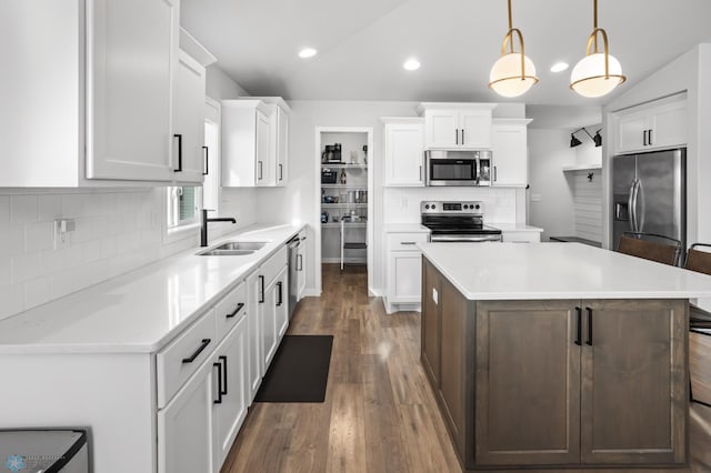 3682 Merrifield Dr S, Fargo, ND 58104 - kitchen with stainless steel appliances, a sink, a center island, decorative backsplash, and wood finished floors