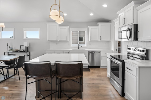 3682 Merrifield Dr S, Fargo, ND 58104 - kitchen featuring stainless steel appliances, a sink, decorative backsplash, light countertops, and wood finished floors