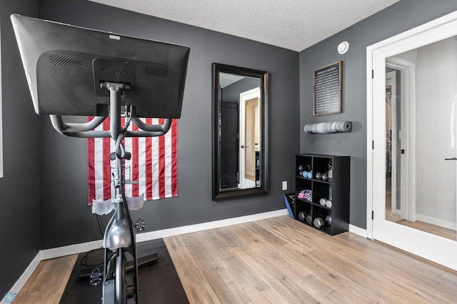 3682 Merrifield Dr S, Fargo, ND 58104 - exercise room with wood finished floors, baseboards, and a textured ceiling