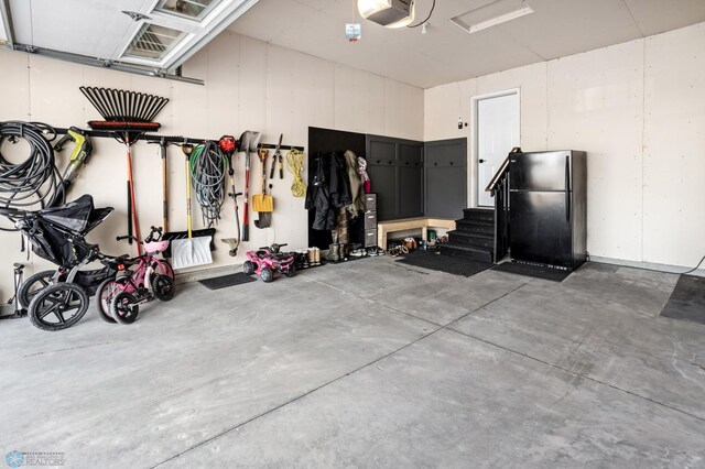 3682 Merrifield Dr S, Fargo, ND 58104 - garage featuring freestanding refrigerator and a garage door opener
