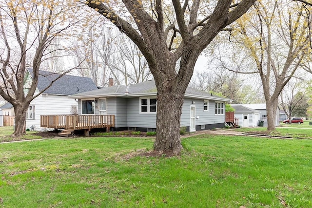 back of property with a wooden deck, a yard, and a chimney