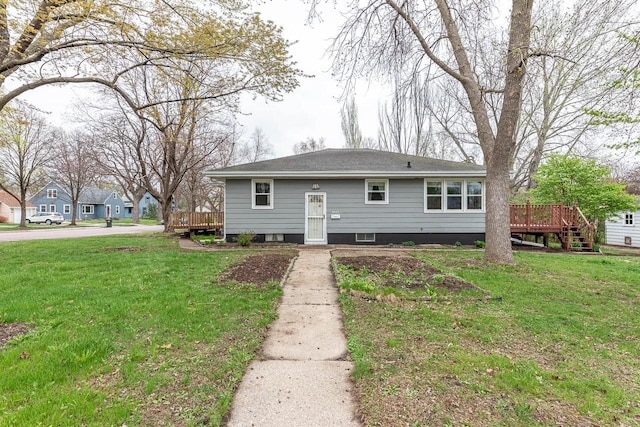 bungalow with roof with shingles, a front lawn, and a deck