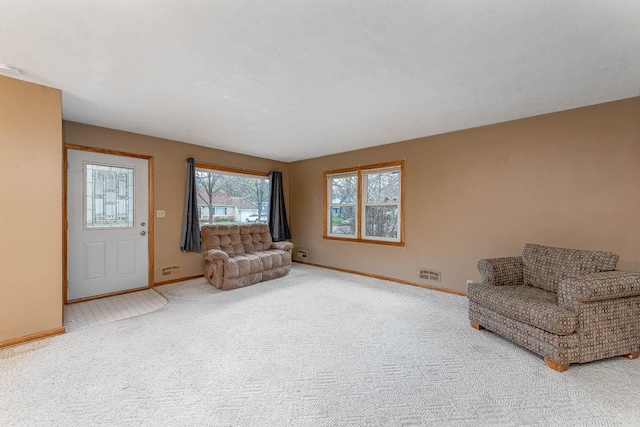 unfurnished living room featuring carpet floors and baseboards