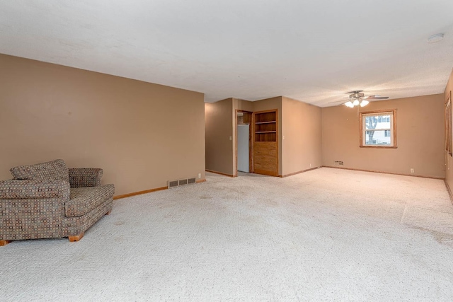 unfurnished living room with carpet flooring, a ceiling fan, baseboards, and visible vents