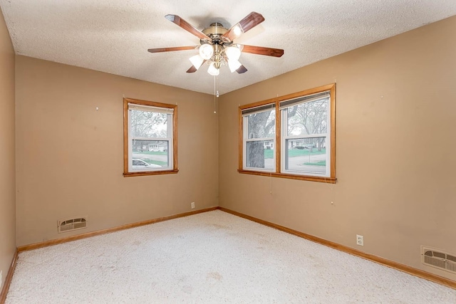 unfurnished room featuring visible vents, a textured ceiling, ceiling fan, and baseboards