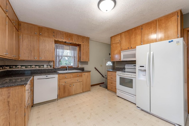 kitchen with white appliances, a textured ceiling, a sink, and light floors