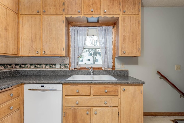 kitchen featuring dark countertops, a sink, and dishwasher