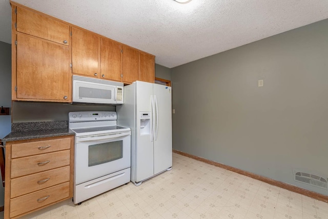 kitchen featuring visible vents, light floors, and white appliances