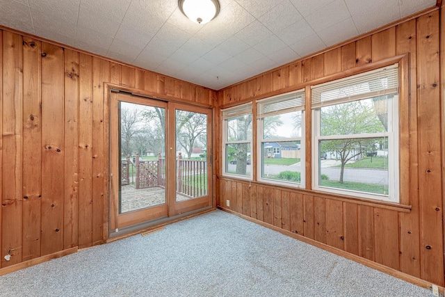 interior space featuring wooden walls, carpet floors, and visible vents