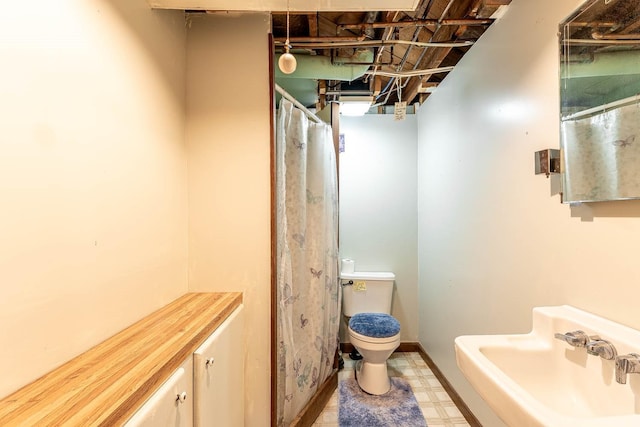 bathroom featuring a sink, tile patterned floors, and toilet