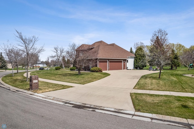 view of front of property featuring a garage, concrete driveway, and a front lawn