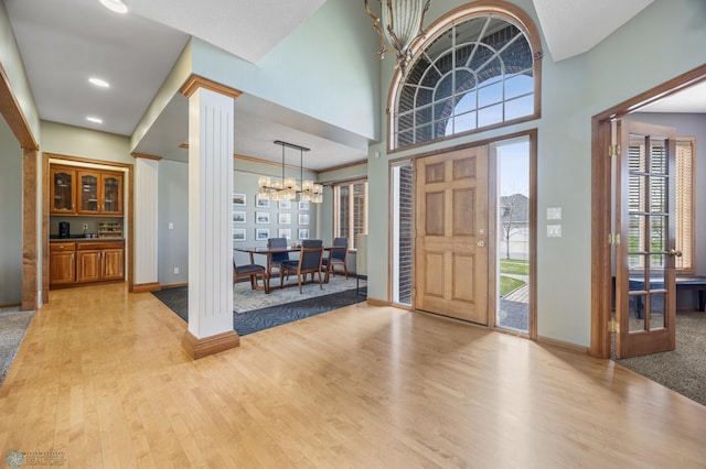 foyer with baseboards, plenty of natural light, and light wood-style floors