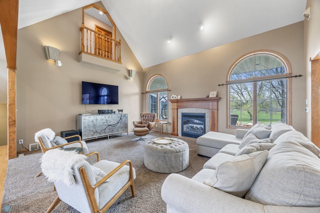 carpeted living room with a tiled fireplace, high vaulted ceiling, and a wealth of natural light