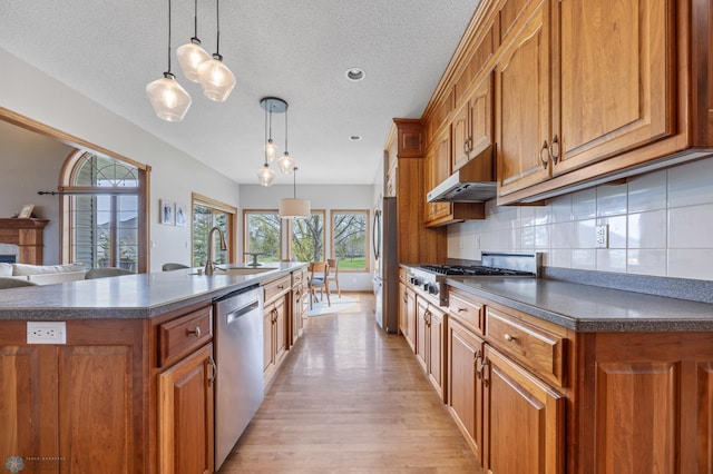 kitchen featuring dark countertops, brown cabinetry, and stainless steel appliances