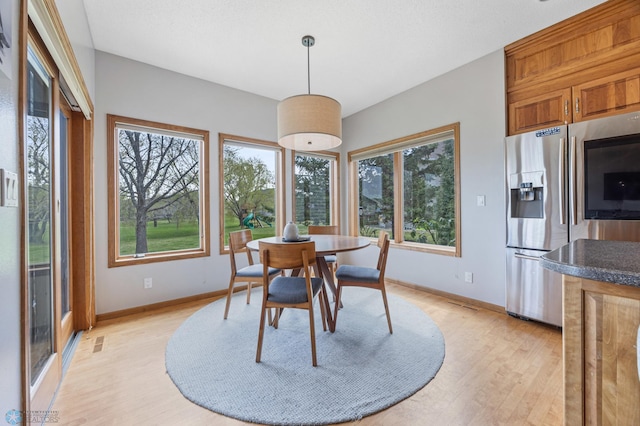 dining room featuring light wood-style floors, baseboards, and visible vents