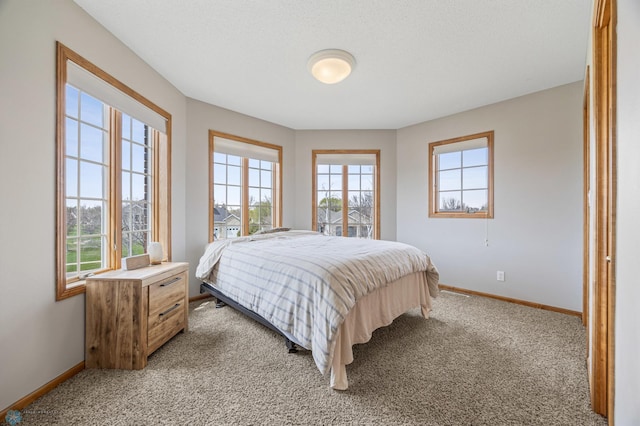 bedroom with baseboards and light carpet
