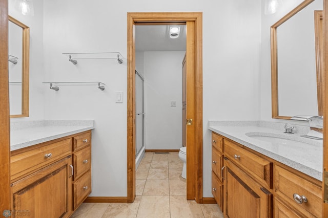 full bath with a stall shower, tile patterned floors, vanity, baseboards, and toilet