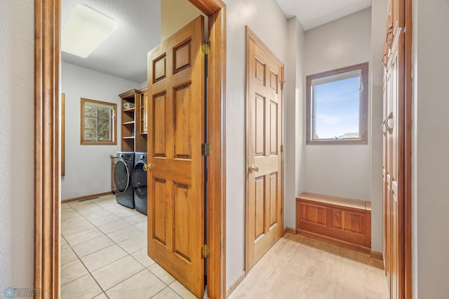 corridor featuring baseboards and washer and clothes dryer
