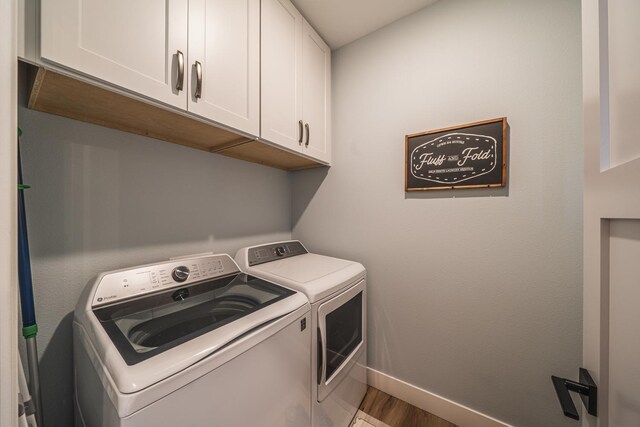 17292 Boyer Lake Rd, Lake Park, MN 56554 - laundry area featuring baseboards, washing machine and dryer, cabinet space, and wood finished floors