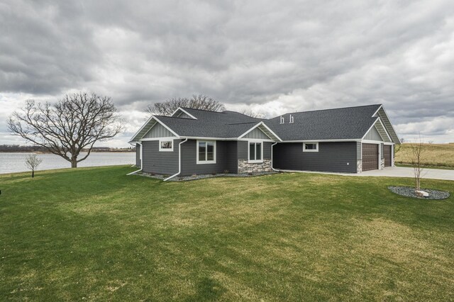 17292 Boyer Lake Rd, Lake Park, MN 56554 - view of front of house featuring a water view, board and batten siding, concrete driveway, and a front lawn