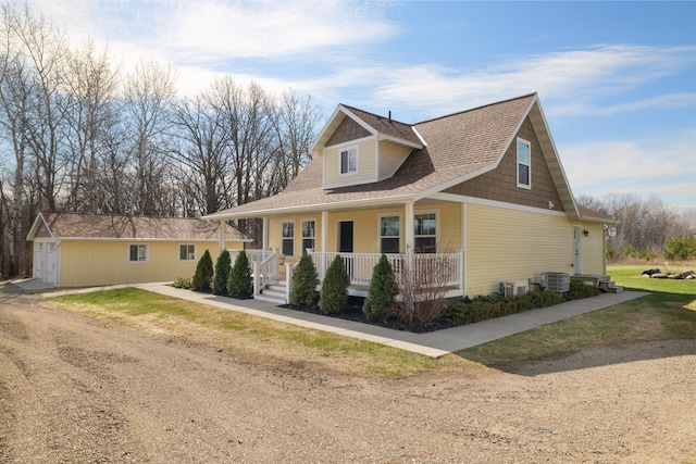 craftsman inspired home with a porch, central AC, and roof with shingles