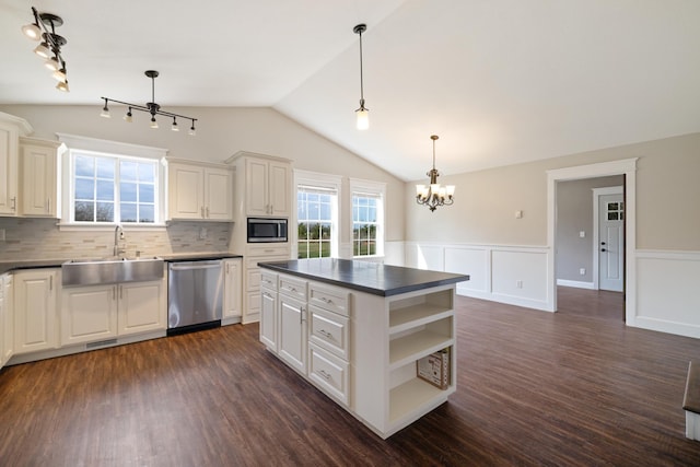 kitchen with dark countertops, appliances with stainless steel finishes, open shelves, and a sink