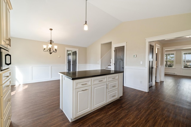 kitchen featuring dark wood-style flooring, wainscoting, dark countertops, built in microwave, and a notable chandelier