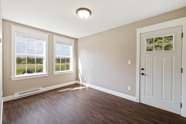 spare room featuring baseboards, dark wood-type flooring, and a baseboard radiator