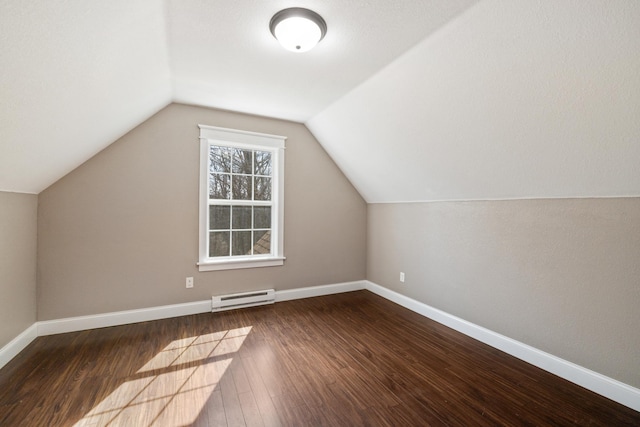additional living space featuring baseboards, vaulted ceiling, baseboard heating, and wood finished floors
