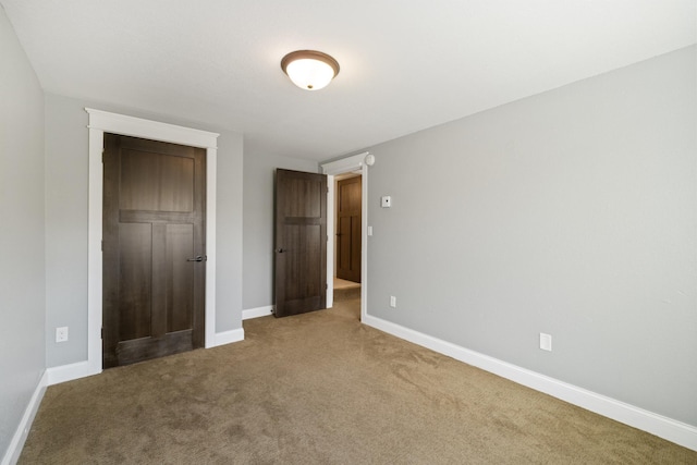 unfurnished bedroom with baseboards and carpet