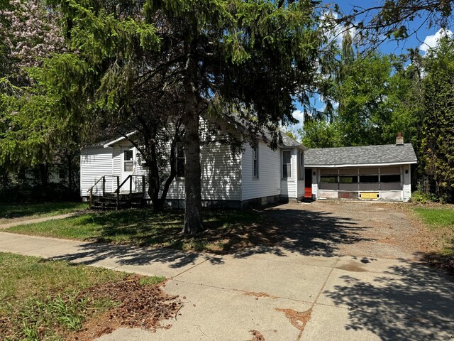 128 4th St NW, Aitkin, MN 56431 - view of front of home with concrete driveway and a sunroom
