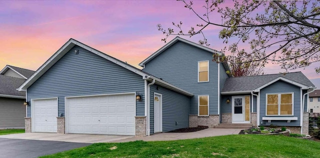 traditional home with a yard, brick siding, an attached garage, and aphalt driveway