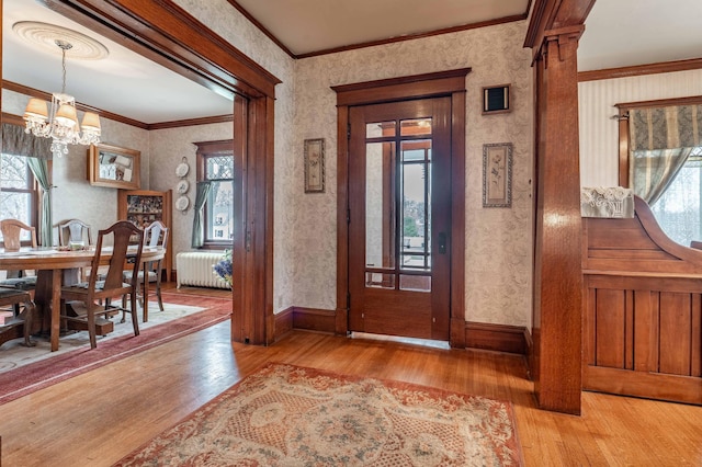 foyer entrance featuring an inviting chandelier, plenty of natural light, and hardwood / wood-style flooring