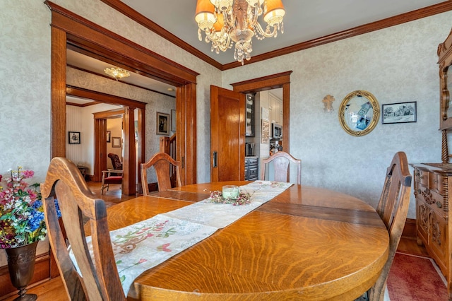 dining space with crown molding, a notable chandelier, and wallpapered walls