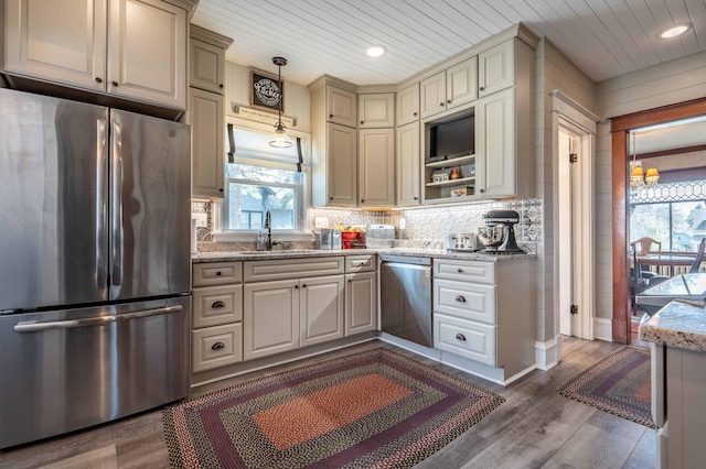 kitchen featuring a sink, appliances with stainless steel finishes, backsplash, and a healthy amount of sunlight