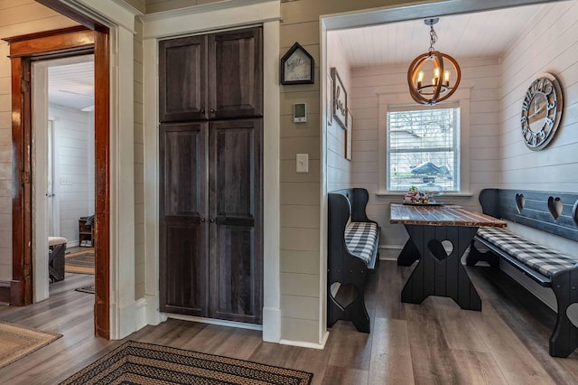 interior space with wood walls, a chandelier, and wood finished floors