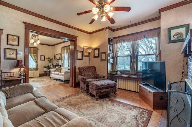 living room featuring light wood-type flooring, ceiling fan, and radiator heating unit