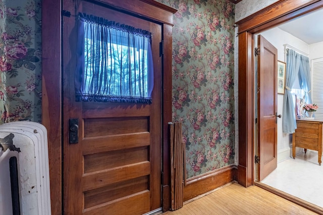 details with baseboards, wood finished floors, and wallpapered walls
