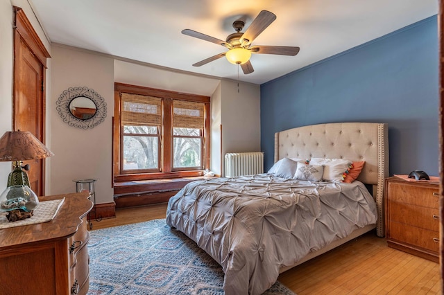bedroom with radiator, ceiling fan, and light wood-type flooring