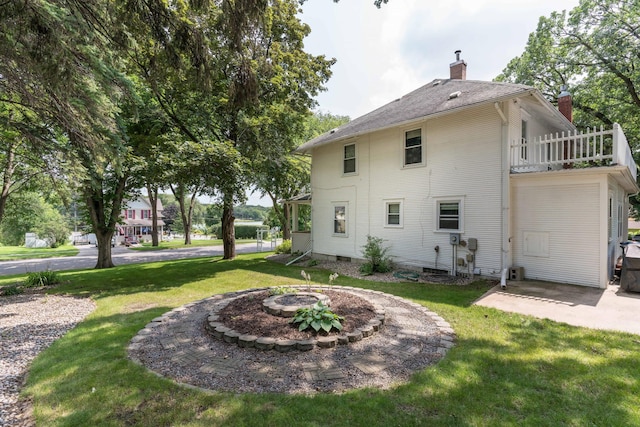 view of property exterior with a lawn, a patio area, a balcony, and a chimney