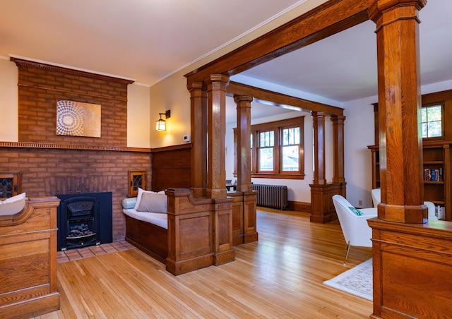 1043 Lincoln Ave, Saint Paul, MN 55105 - bedroom with radiator, ornate columns, light wood-style flooring, a fireplace, and ornamental molding