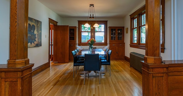 1043 Lincoln Ave, Saint Paul, MN 55105 - dining area with radiator heating unit, decorative columns, and light wood-type flooring